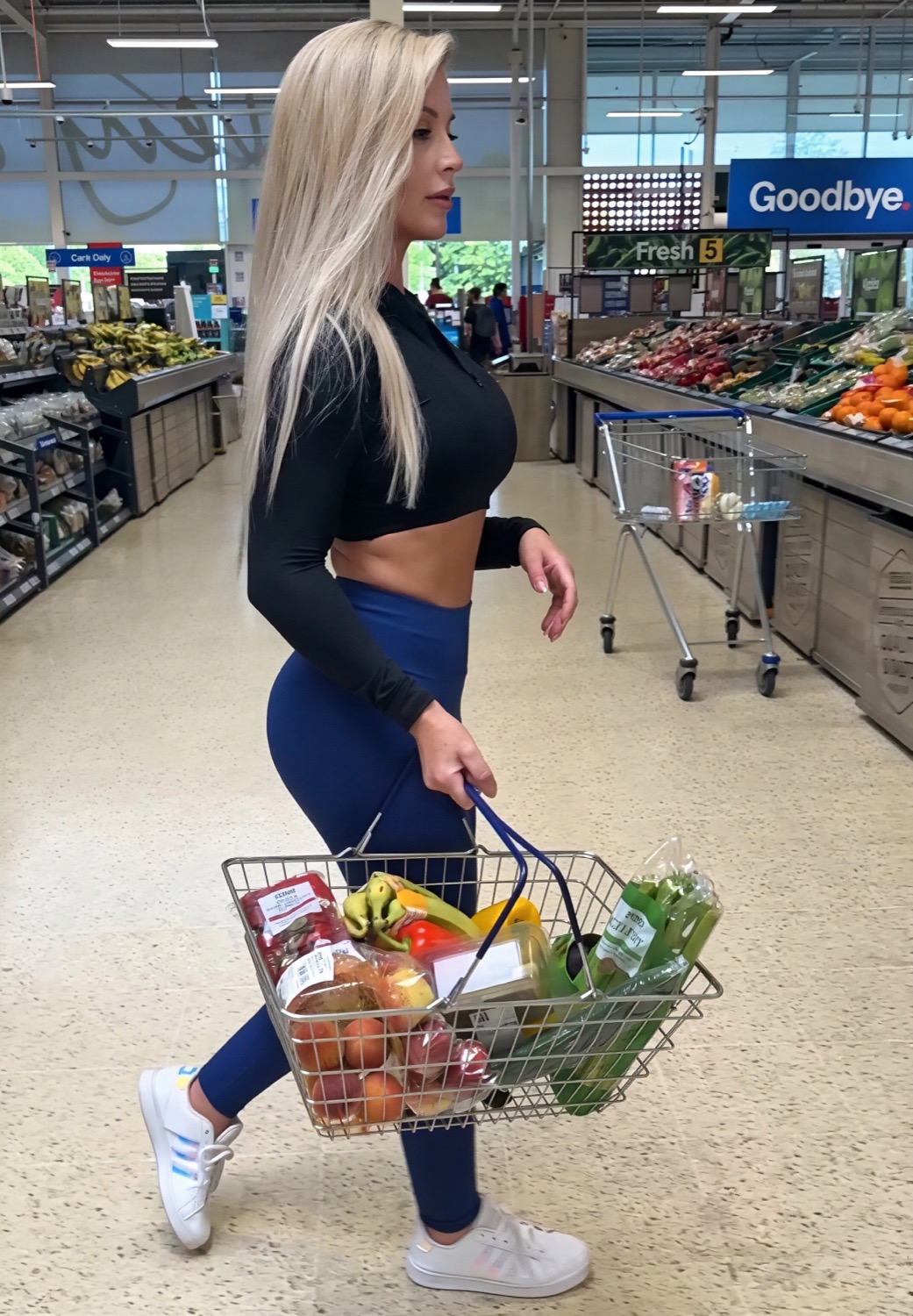 Miss Sally walking through the produce aisle with her shopping basket